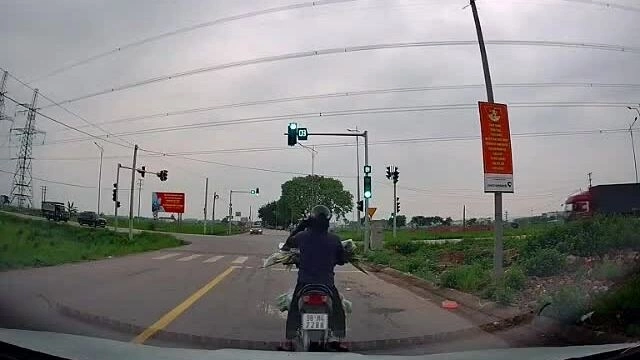 Vô tư nghe điện thoại người phụ nữ đi xe máy chặn lối ôtô