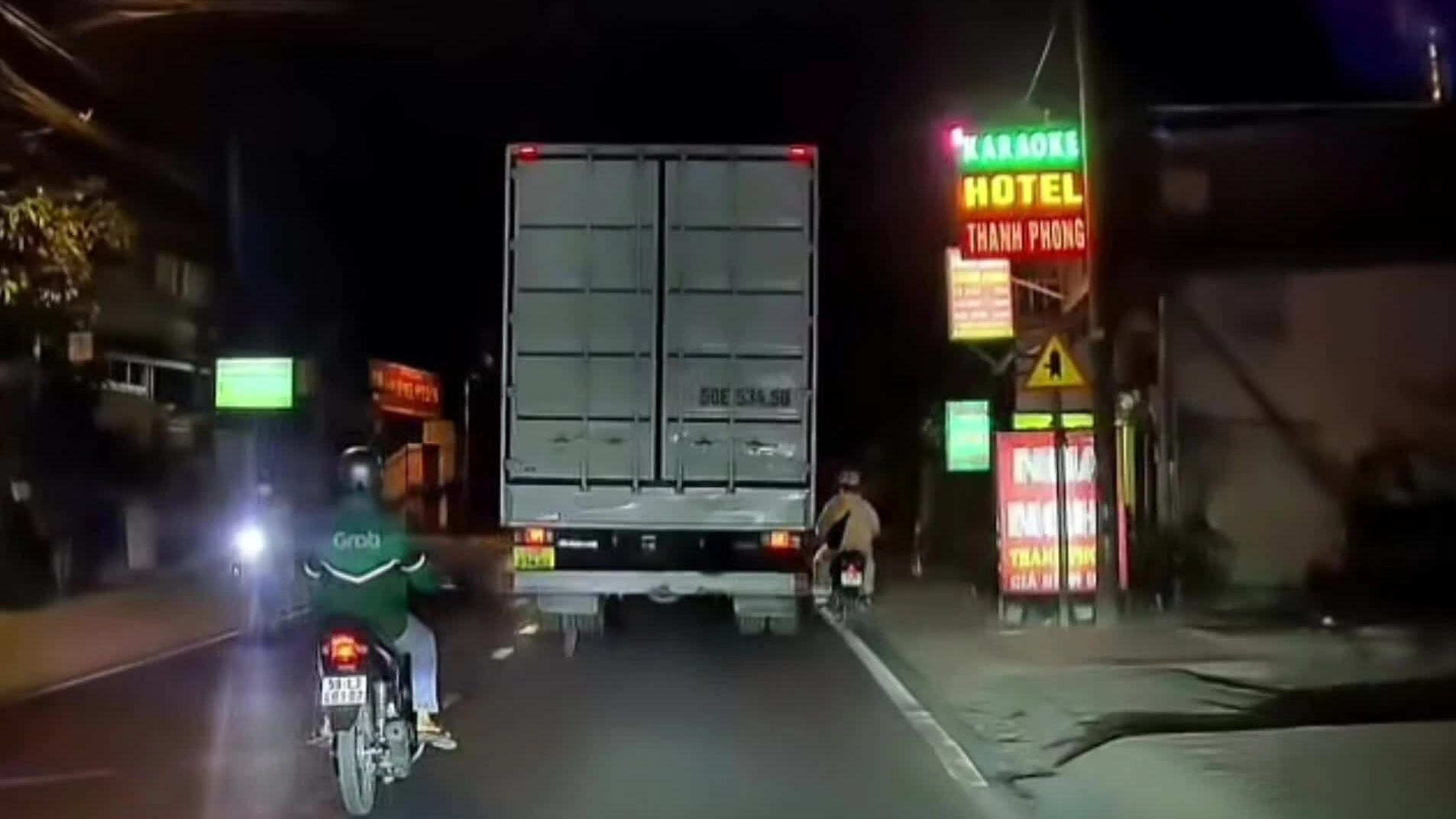 Xe máy va chạm khi 'cặp hông' xe tải trên đường hẹp