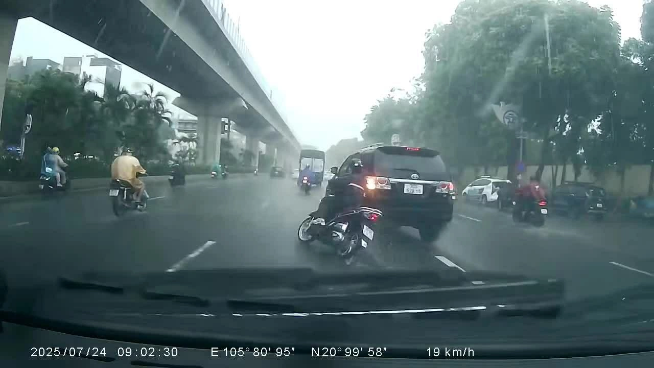 Ôtô hất ngã người đi xe máy trong mưa