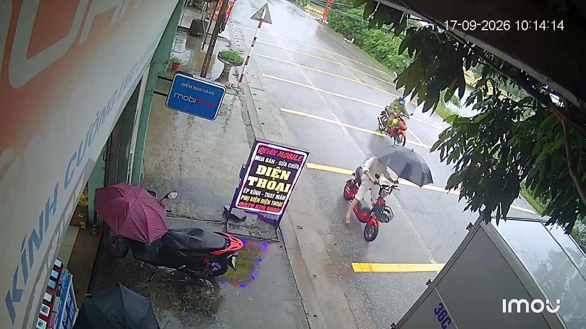 be-gai-cam-o-khi-di-xe-dap-dien-tong-xe-tai-dang-do-1789722288 Bé gái cầm ô khi đi xe đạp điện, tông xe tải đang đỗ