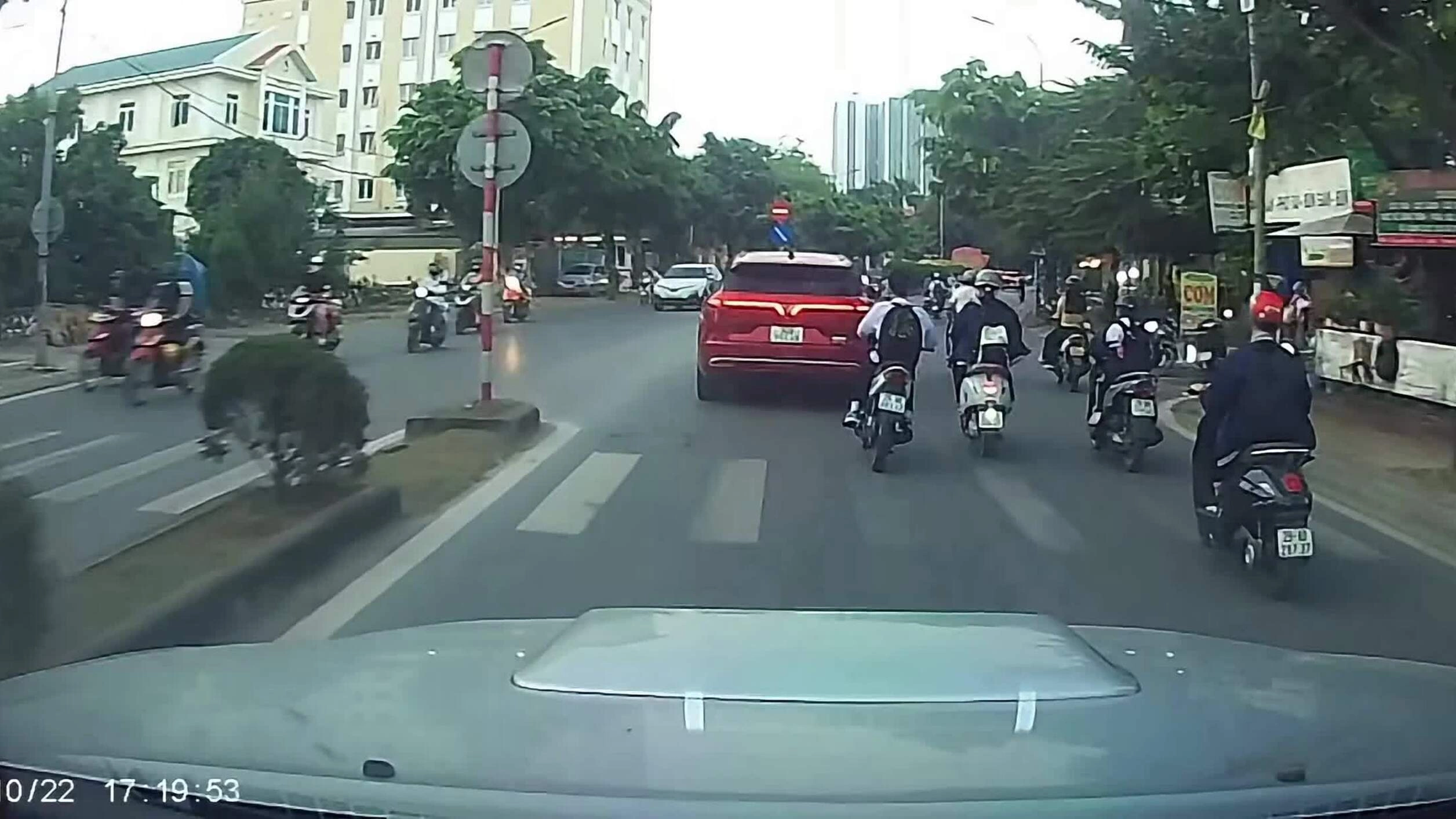len-qua-khe-hep-cau-be-di-xe-dien-nga-sat-banh-oto-1792741568 Len qua khe hẹp, cậu bé đi xe điện ngã sát bánh ôtô
