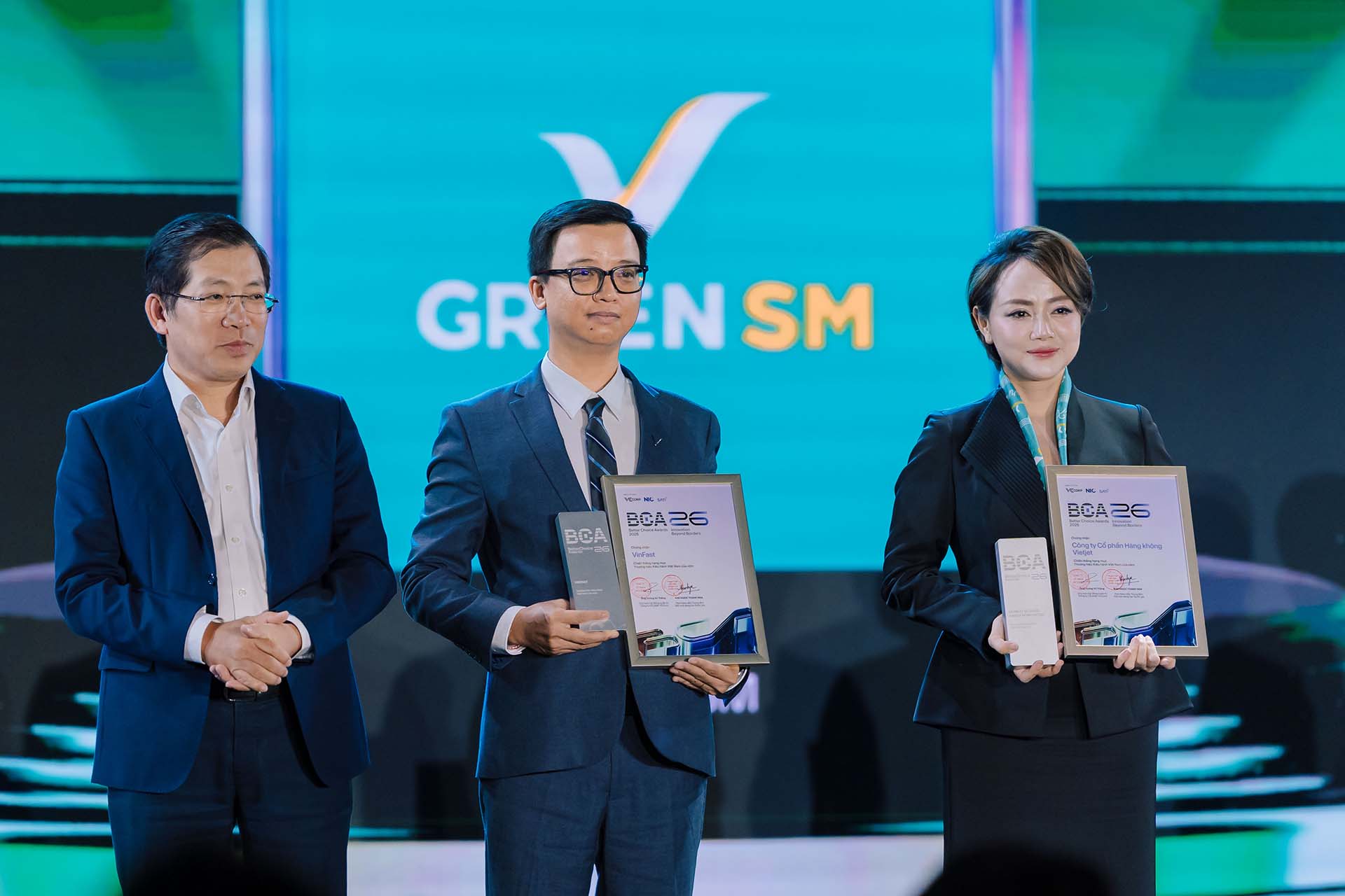 Ông Nguyễn Hồng Nhật, Tổng giám đốc VinFast Ô tô thị trường Việt Nam (giữa) và bà Trần Thanh Thủy, Phó Tổng giám đốc vận hành 2 bánh và giao hàng GSM nhận giải thưởng “Thương hiệu kiêu hãnh Việt Nam của năm” từ đại diện ban tổ chức